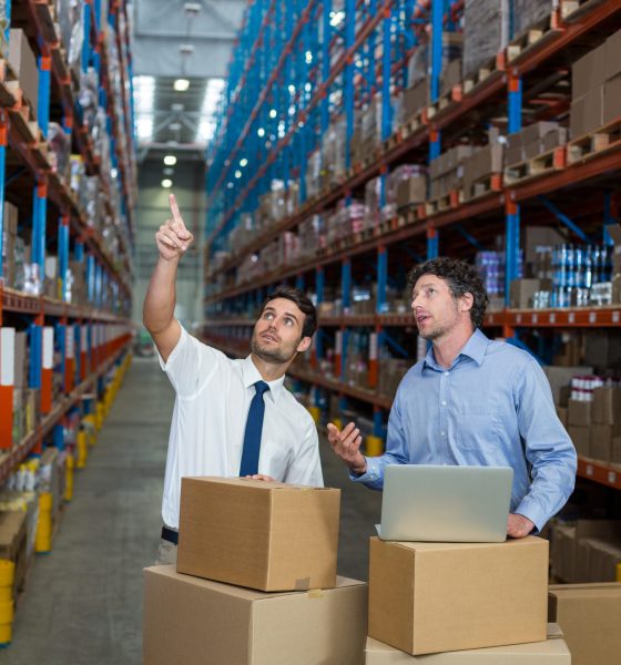 Managers are looking up and pointing shelves in a warehouse Proficircle | Warehouse managers planing store management